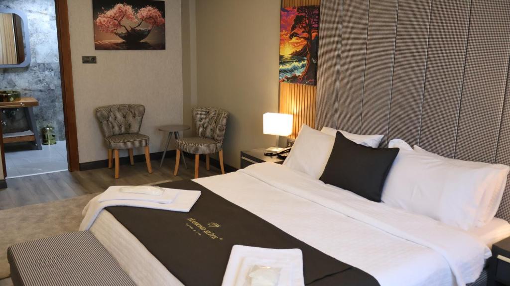 um quarto de hotel com uma cama grande e cadeiras em Dİamond Elit Otel&Spa Center em Esmirna