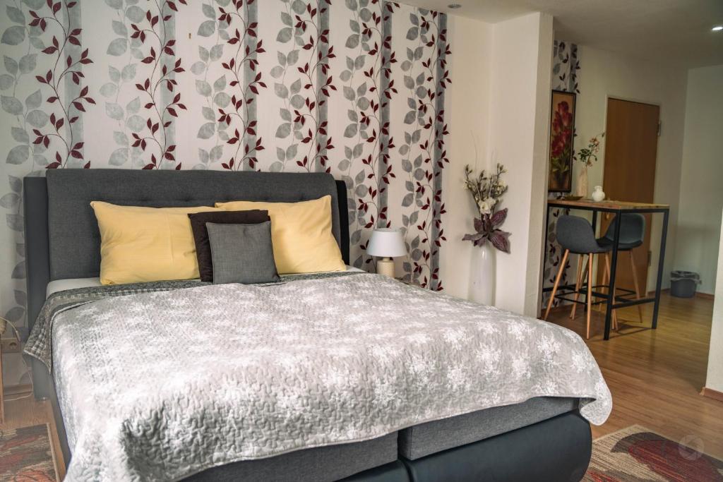een slaapkamer met een groot bed met een grijs dekbed bij Wild West Hotel in Fichtelberg
