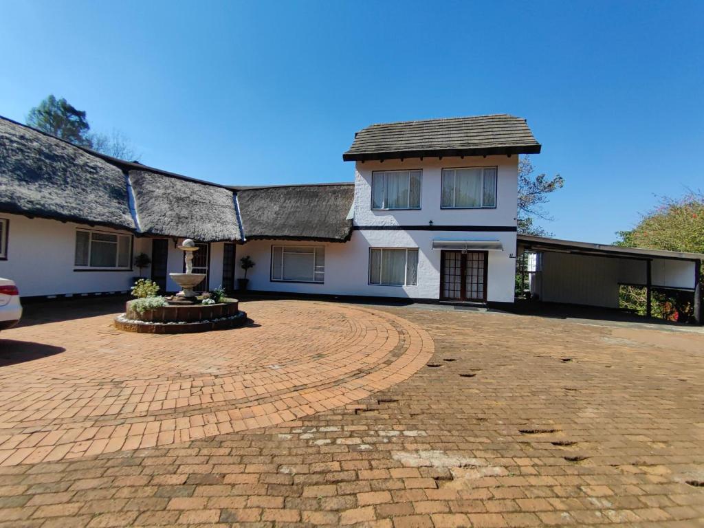 una casa con una entrada de ladrillo delante de ella en Emfuleni Boughton Inn, en Pietermaritzburg