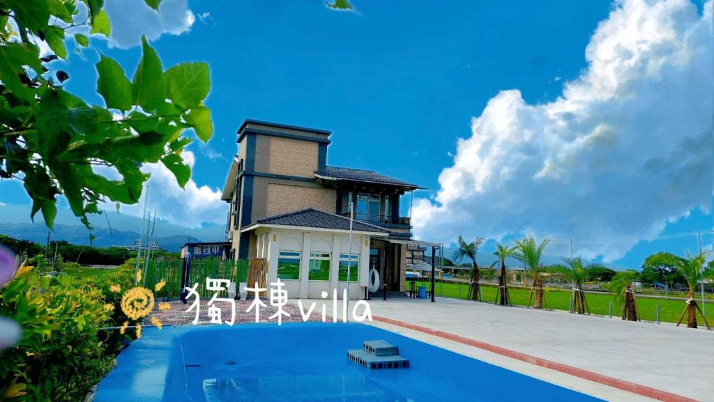a villa with a swimming pool and a house at Happy play villa in Yuanshan
