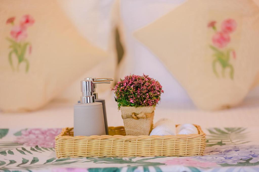 un panier avec un distributeur de savon et des fleurs sur une table dans l'établissement le bella1912, à Galle