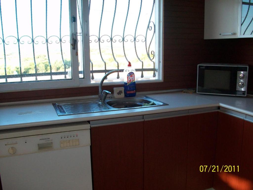 encimera de cocina con fregadero y ventana en Çeşme full eşyalı en Kavak