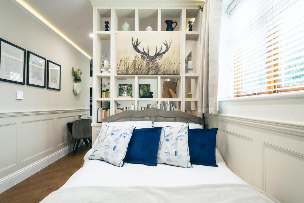 um quarto com uma cama com almofadas azuis em The Former New Inn em Ashby de la Zouch