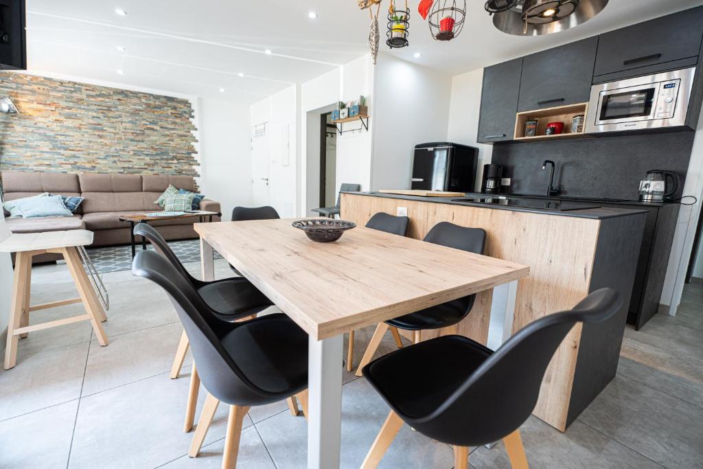 una cucina e una sala da pranzo con tavolo e sedie in legno di Appartement des Sorcieres - Witches Apartment a Sélestat