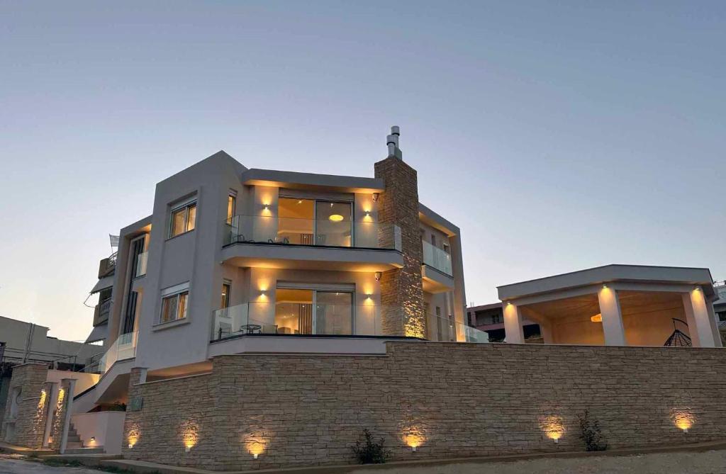 a large house with lights on top of a brick wall at Elia Luxury Residence in Chalkida