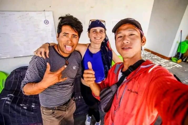 Trois hommes posant une photo avec leurs pouces dans l'établissement Nomads Club, à Nazca