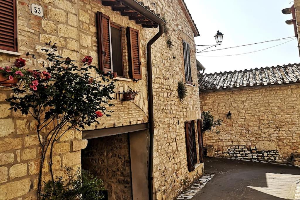 een oud stenen gebouw met een deur en een plant bij La Casa sull'Archetto in Corciano