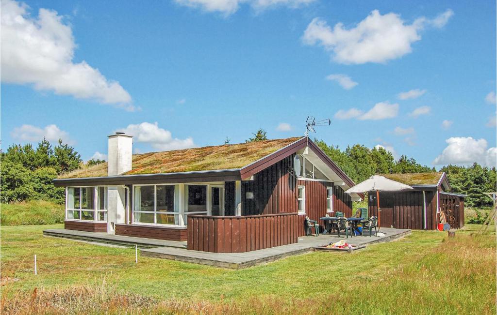 a small house with a deck and a patio at Amazing Home In Lkken With 3 Bedrooms And Sauna in Grønhøj