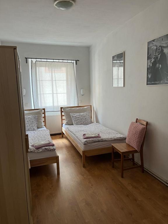 pokój z 2 łóżkami i krzesłem w obiekcie Apartment Zámecká w mieście Děčín