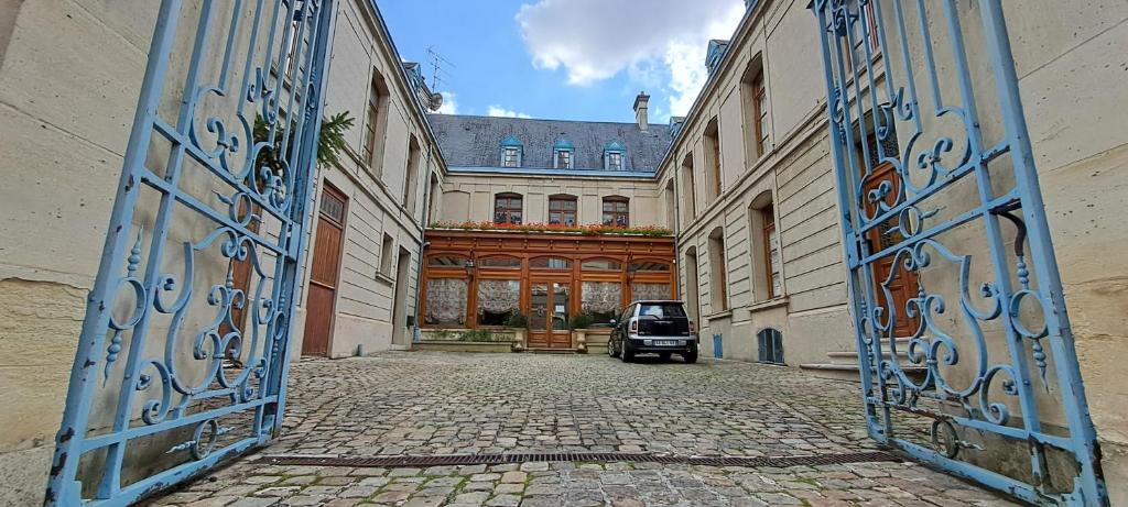 una puerta a un edificio con un coche aparcado en él en Hôtel Particulier des Canonniers, en Saint-Quentin