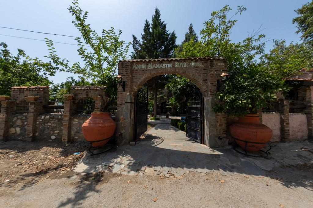 an entrance to a building with two large vases at Antique Manastir Boutique Hotel in Edremit