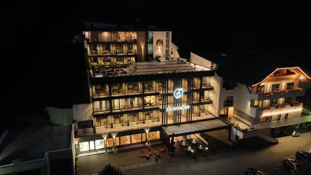 un bâtiment avec une façade éclairée la nuit dans l'établissement Hotel Zalwonder, à Ischgl