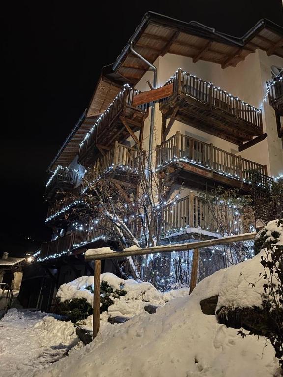 a building with snow on the ground in front of it at Maison Caramel Chalet in Landry