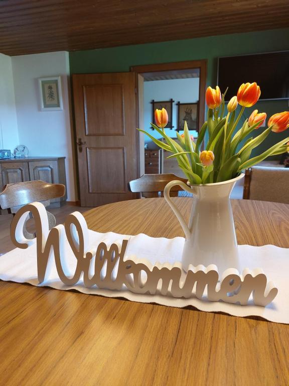 a table with a vase of orange tulips on it at Vorderweinaugut in Annaberg im Lammertal