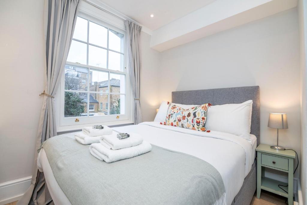 1 dormitorio con 1 cama con toallas en Stylish first floor 1BR flat in Notting Hill, en Londres