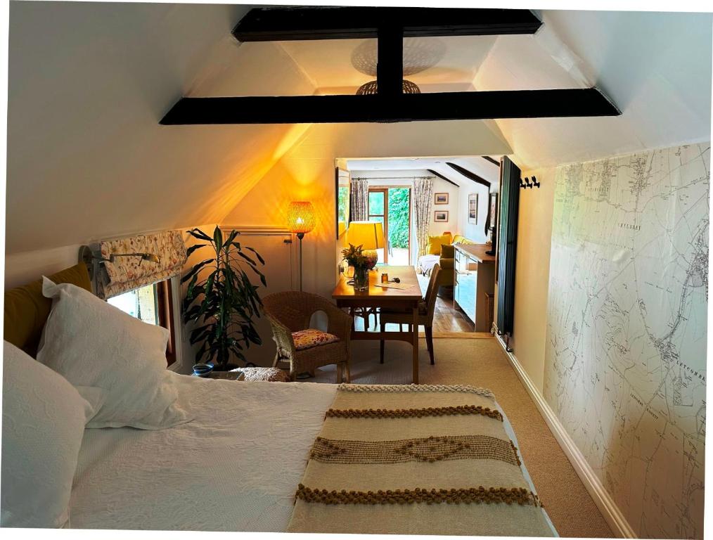 a bedroom with a bed and a table and a dining room at Thatchcombe B&B in Wantage
