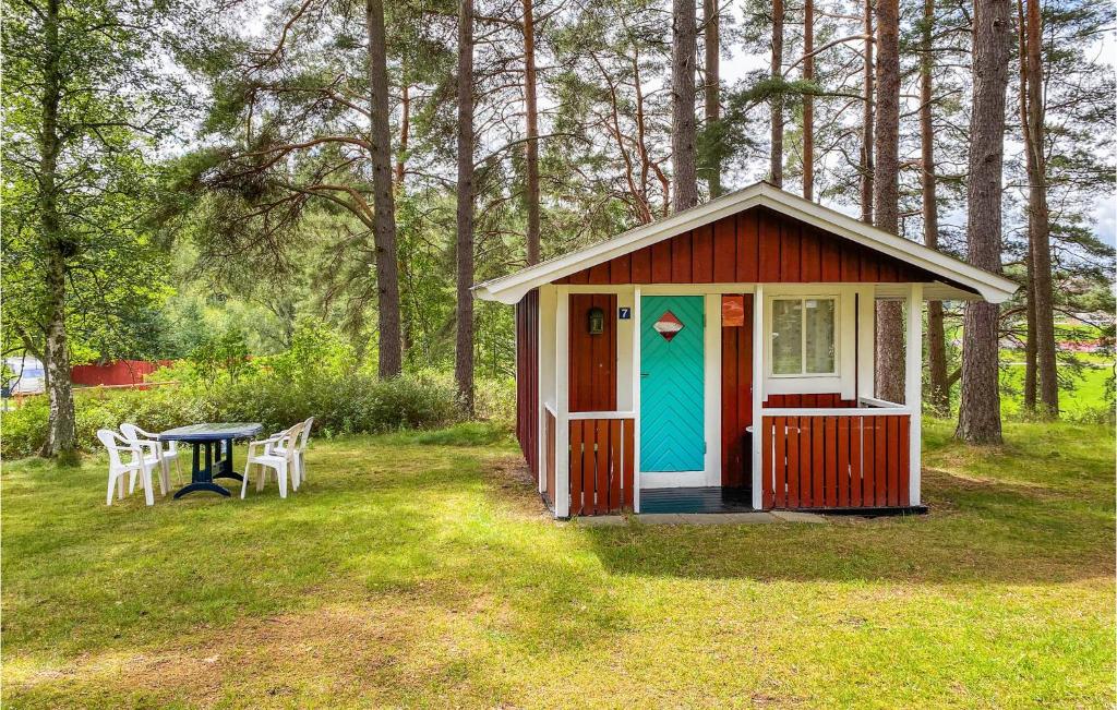 永比的住宿－Cozy Home In Ljungby With Kitchen，一个小红棚子,配有桌子和蓝色的门