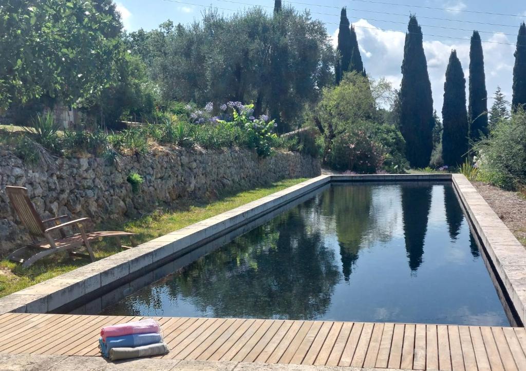 une piscine dans un jardin avec une terrasse en bois dans l'établissement La petite maison, à Châteauneuf