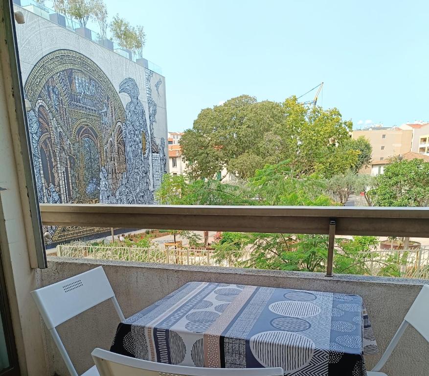 une table et des chaises sur un balcon avec une fenêtre dans l'établissement Deux pièces climatisé avec balcon Vieil Antibes, à Antibes