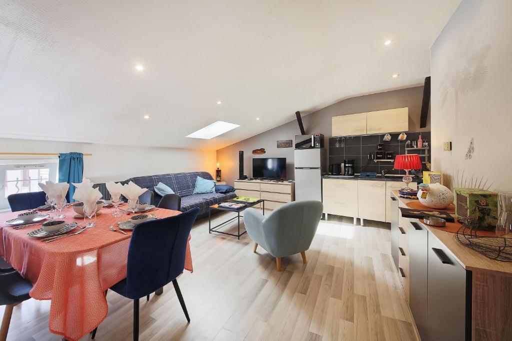 a kitchen and living room with a table and chairs at Le Barral in Castres