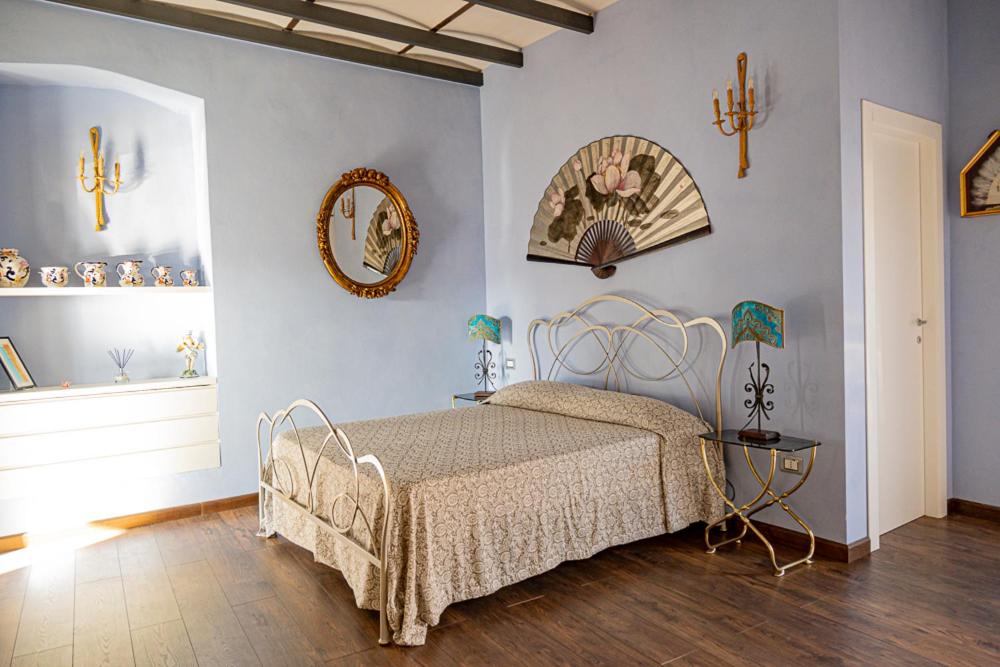 Un dormitorio con una cama y algunos cuadros en la pared. en Attico San Biagio, en Lecce