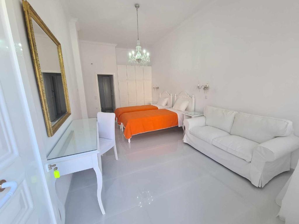 a white living room with a couch and a bed at NN Rooms and Suites near Athens Airport in Spáta
