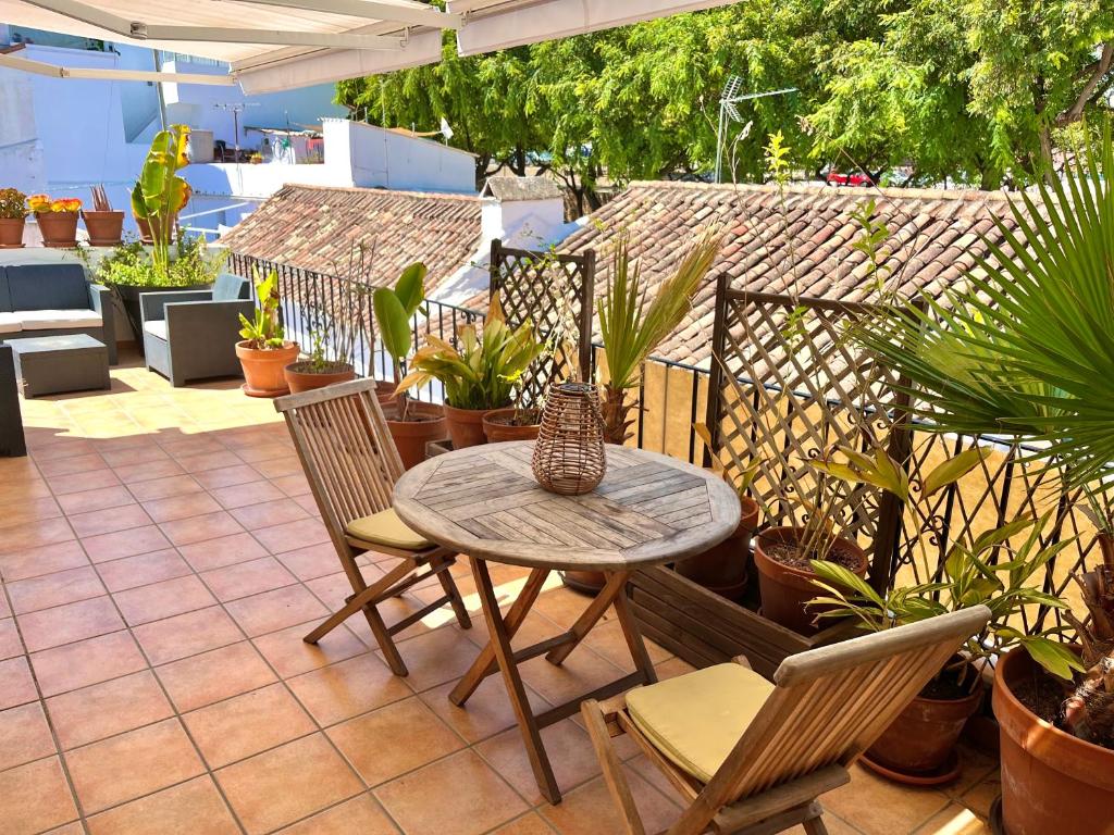 un patio con mesa, sillas y macetas en Big terrace penthouse in Marbella Old Town, en Marbella