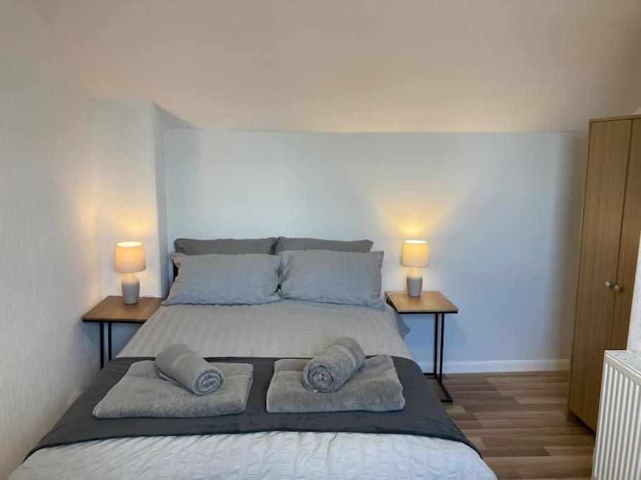 a bedroom with a large bed with two lamps on two tables at Trent Bridge house in Nottingham