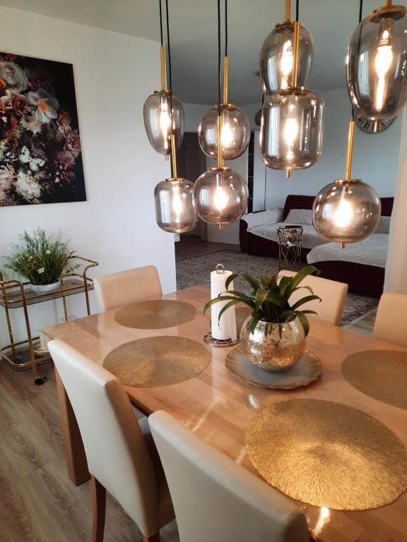 a dining room with a table with chairs and lights at Moderne 3Zimmer Wohnung, in Königsbrunn bei Augsburg in Königsbrunn