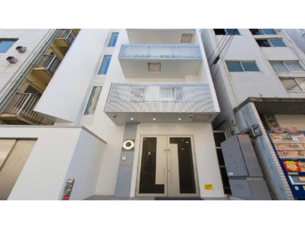 a view of a white building with a door at Guesthouse La Cava women's single room / Vacation STAY 21865 in Yokohama