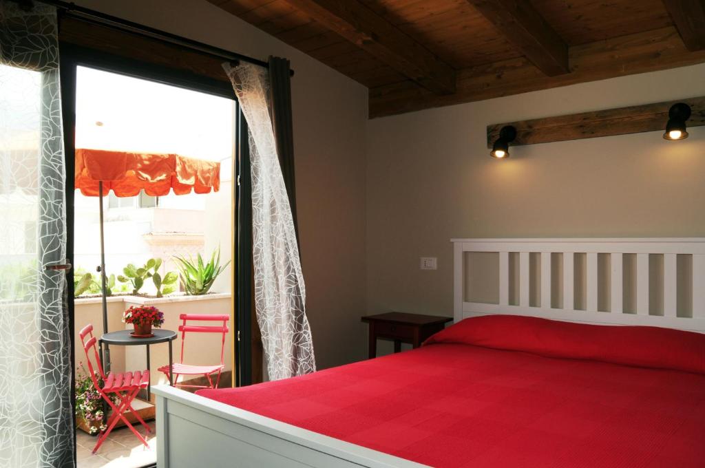 una camera con un letto rosso e una grande finestra di TerraSole Bakery B&B a Terrasini