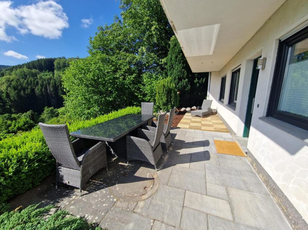 a patio with a table and chairs on a house at Ferienwohnung Ruthenaar in Willingen