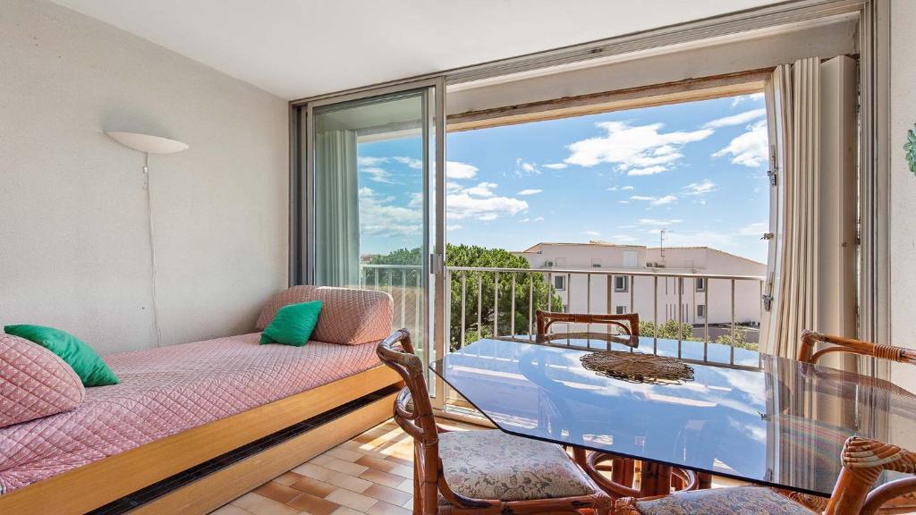 une chambre avec un balcon avec un lit et une fenêtre dans l'établissement La Colinne -113- 3 pers, au Cap d'Agde