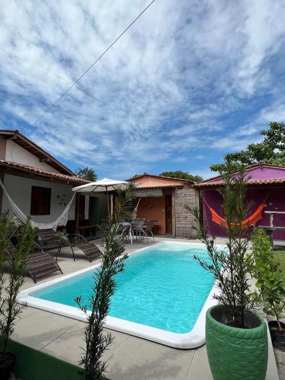 a swimming pool in front of a house at Casa Recanto - Villa Uryah in Caraíva