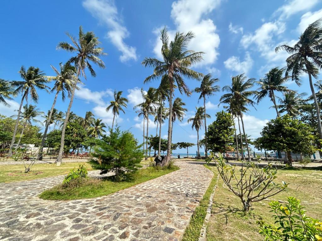 Dewa Daru Resort في كاريمونجاوا: مسار على الشاطئ مع أشجار النخيل