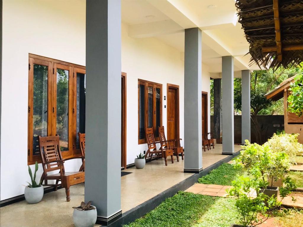 um alpendre de uma casa com cadeiras e plantas em Hotel Hanguk Villa em Dambulla