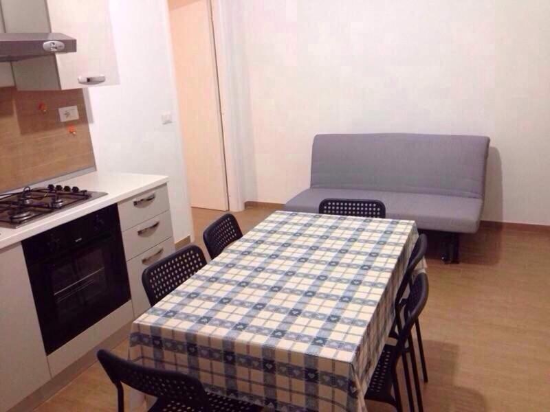 een keuken met een tafel en stoelen met een tafel en een bank bij Casa Mari' 1 in Margherita di Savoia