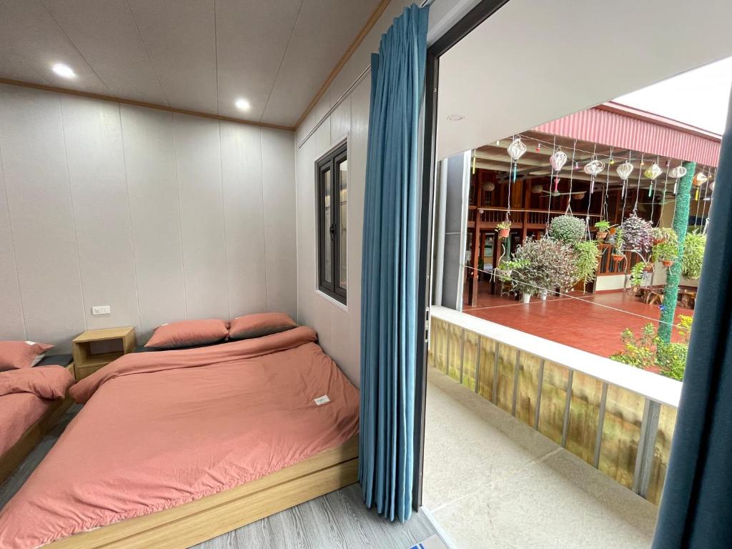 1 dormitorio con 2 camas y ventana con balcón en Homestay Hoa ban en Mộc Châu