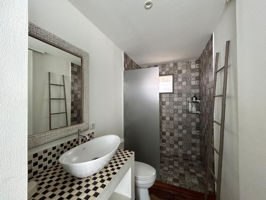 a bathroom with a tub and a toilet and a sink at Meno Suites in Gili Meno