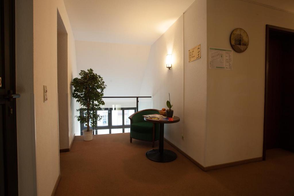 a hallway with a table and a chair in a room at Hotel & Restaurant Klosterhof in Dresden
