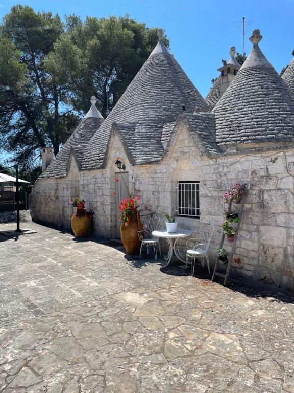 an old stone building with a table and chairs at Trullo Ronzicchio in Cisternino