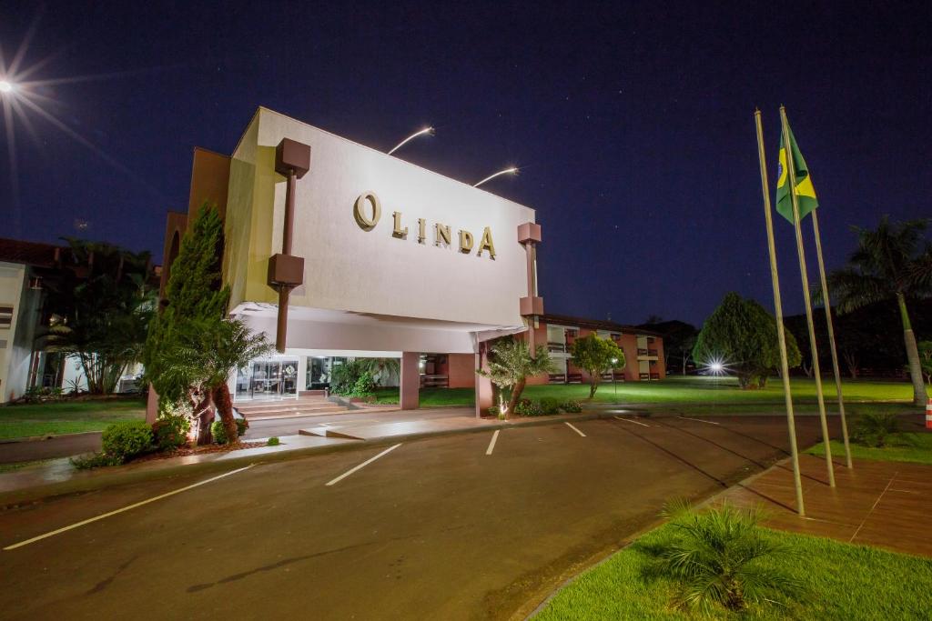 een gebouw met een bord dat 's nachts uima leest bij Olinda Hotel e Eventos in Toledo
