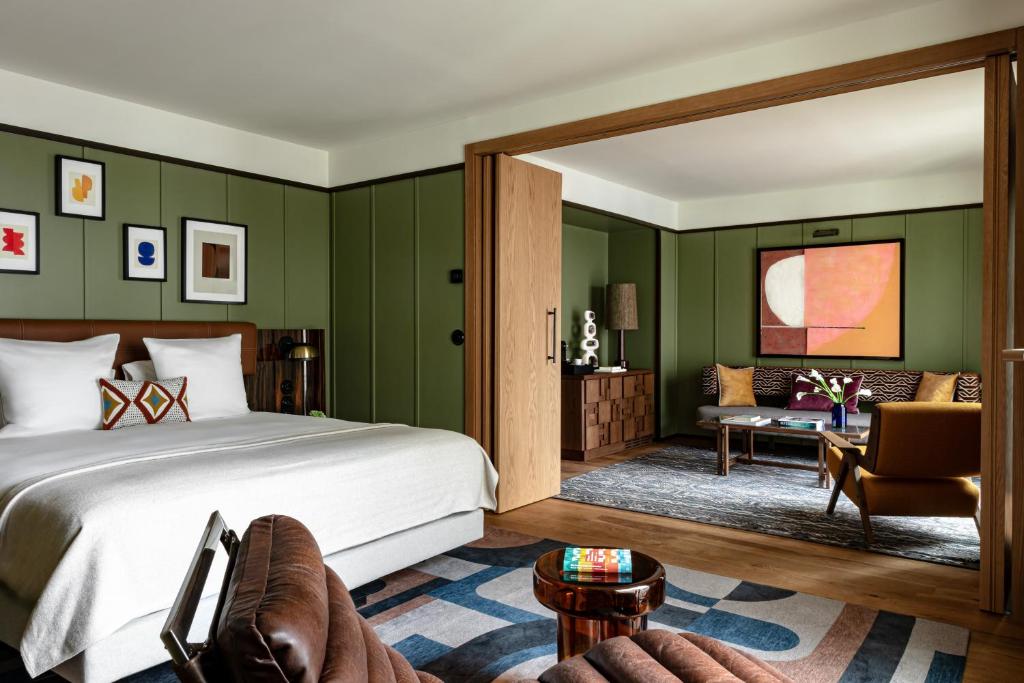 a bedroom with green walls and a bed and a couch at Hotel Norman Paris in Paris