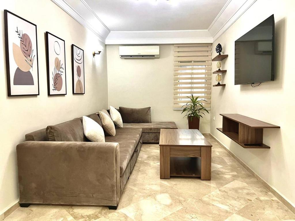 Il comprend un salon doté d'un canapé et d'une télévision à écran plat. dans l'établissement Rabat Central Confort, à Rabat