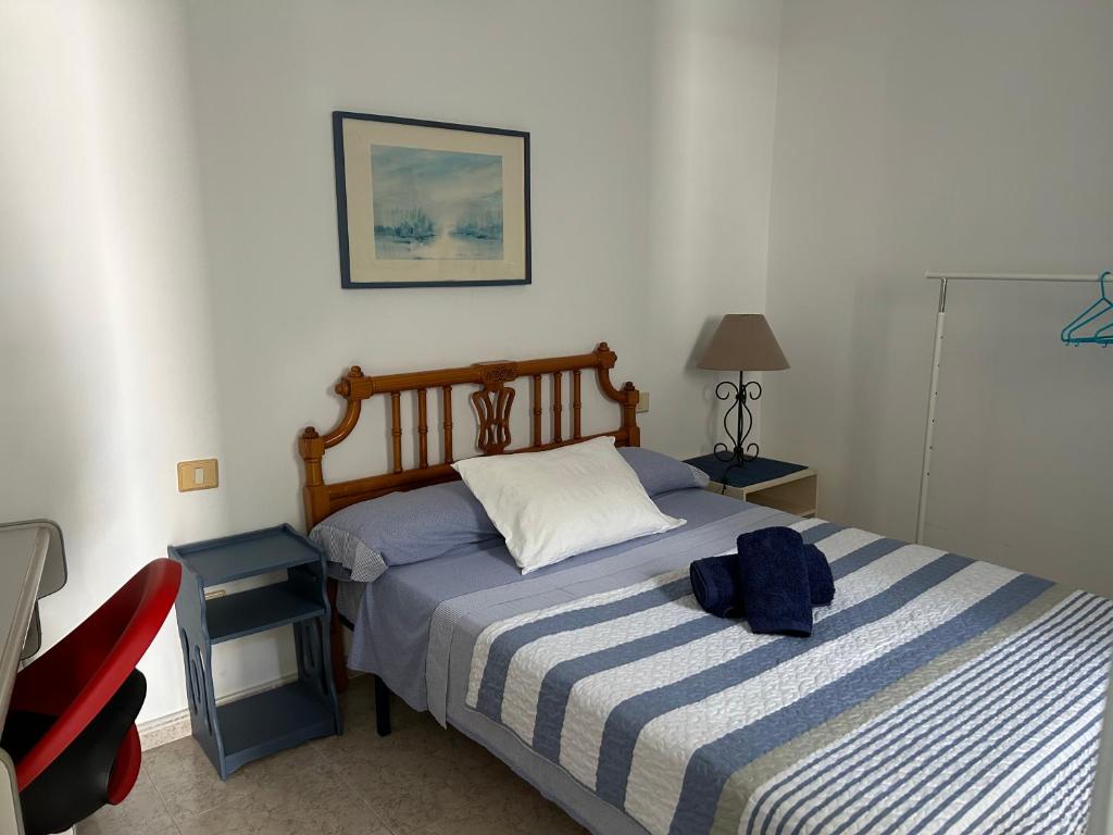 a bedroom with a bed with a blue backpack on it at La Buganvilla rooms in Arrecife