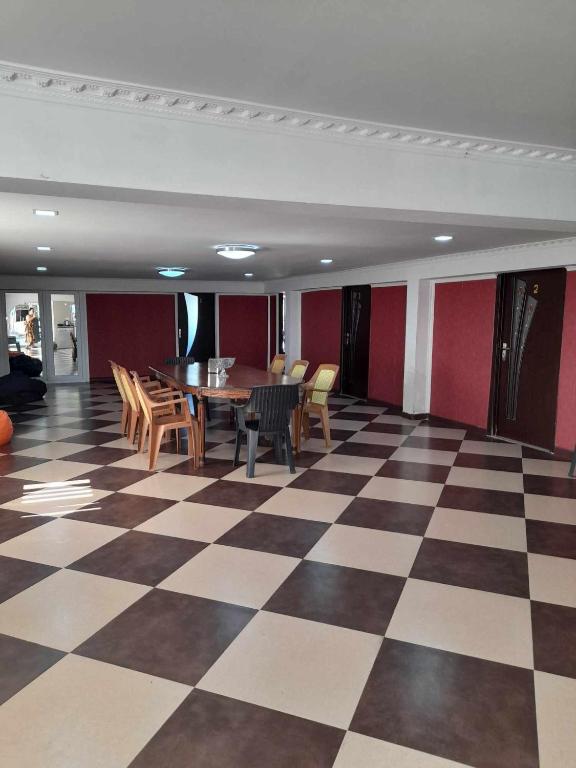 a room with a table and chairs on a checkered floor at Zhanas home anaklia in Anaklia