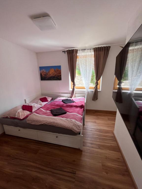 - une chambre avec un lit dans une pièce dotée de fenêtres dans l'établissement Binis Murtalblick, à Pöls
