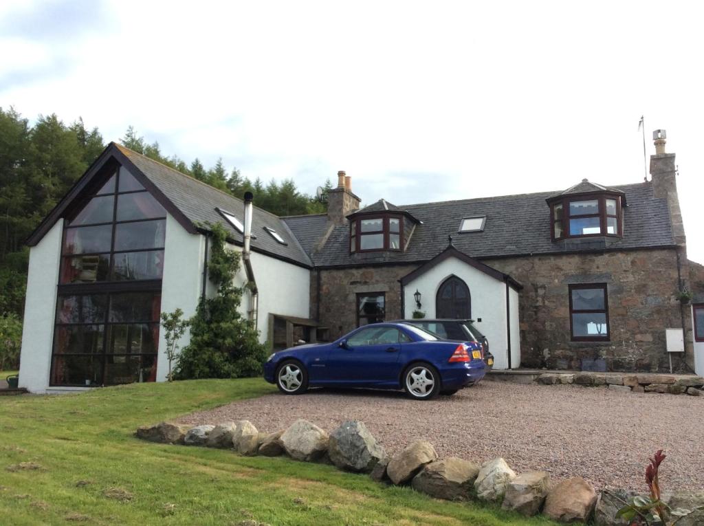 a blue car parked in front of a house at Lochend Farmhouse in Aberdeen