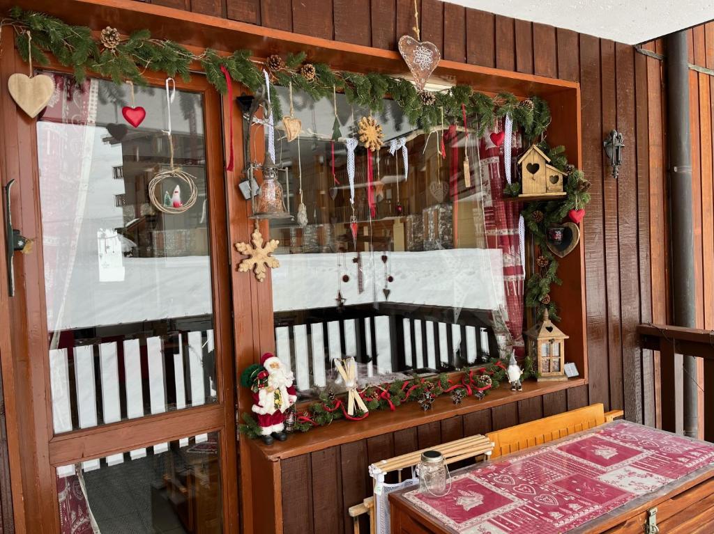 une fenêtre d'une maison avec des décorations de Noël dans l'établissement Le Refuge de Léonor, à Valmorel