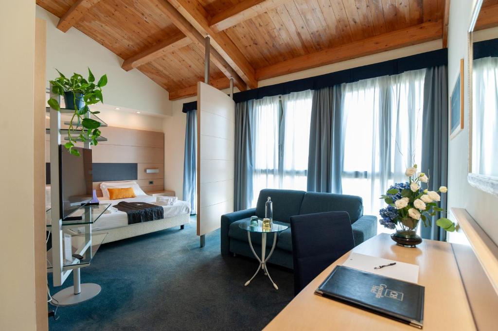 ein Hotelzimmer mit einem Bett und einem Wohnzimmer in der Unterkunft Concordia Hotel in San Possidonio